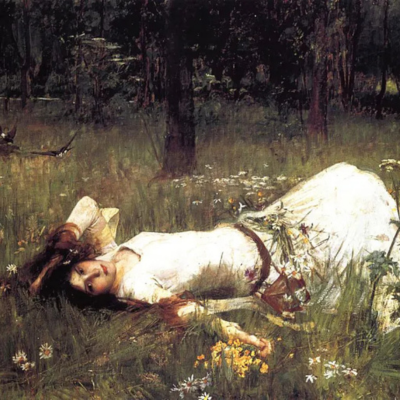 An image of a woman wearing a long, floaty dress laying in the grass with flowers around her looking melancholic.