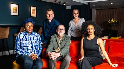 Booker Prize 2025 Judges gathered together by a red sofa.