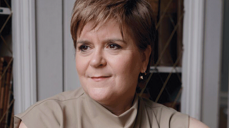 Rolling image of Nicola Sturgeon looking to the left wearing a beige top, the Nara exhibition wall of framed paitings and Ketanji Brown Jackson smiling at the camera wearing black glasses and a black knitted jumper.