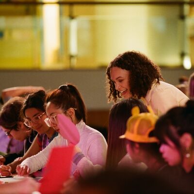 The workshop facilitator engaging with participants working on their collage art