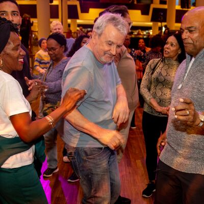 A group of older adults of mixed genders dancing together at a Mix & Move event