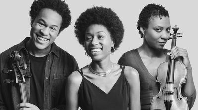 Black and White Image of the three artists smiling holding their instruments