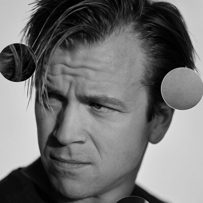 A black and white portrait of someone looking to the left and frowning, there are 7 circles over the image