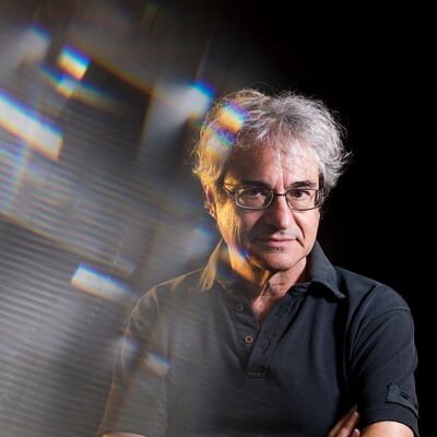 Carlo Rovelli wearing a polo shirt with his arms crossed.