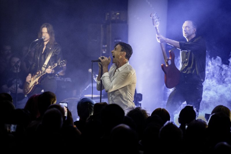 The band on stage under blue lights