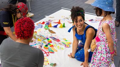 Artist Tasnim Mahdy collaborates with participants who are working on a collective piece of visual art together