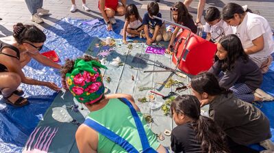 Artist Tasnim Mahdy collaborates with participants who are working on a collective piece of visual art together