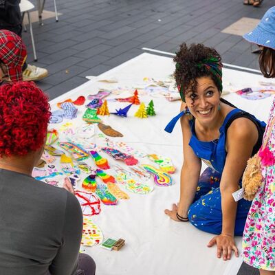 Artist Tasnim Mahdy collaborates with participants who are working on a collective piece of visual art together