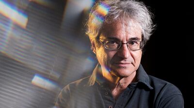 Carlo Rovelli wearing a polo shirt with his arms crossed.