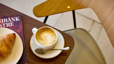 Coffee and croissant on table with chair