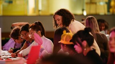The workshop facilitator engaging with participants working on their collage art
