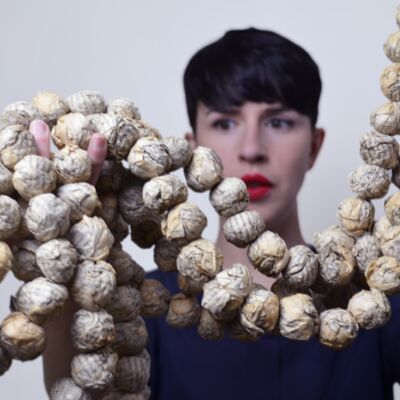 Iris Colomb holding a string of scrunched up paper balls.