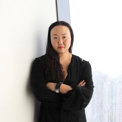 Hanya Yanigahara with her arms crossed against a white background.