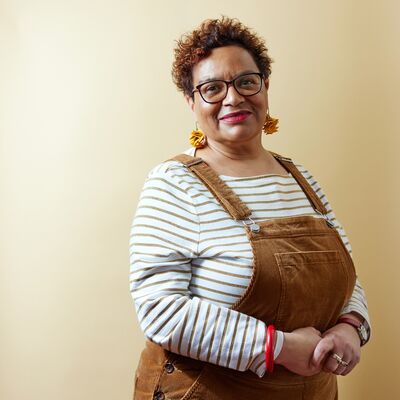 Jackie Kay wearing a striped shirt and brown dungarees.