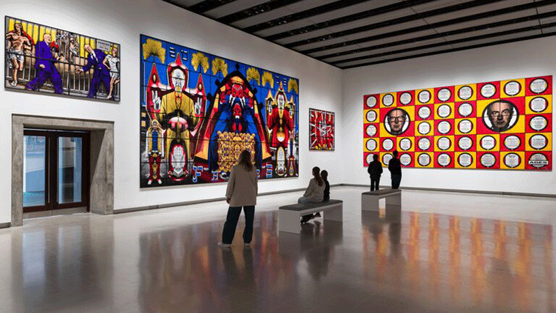 Linton Stephens and Gillian Moore sit side by side on a leather seat in the Southbank Centre's Queen Elizabeth Hall Foyer