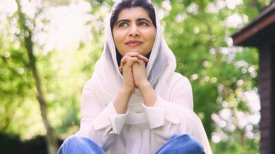 Seated audience members clapping at an event with joy on their faces.