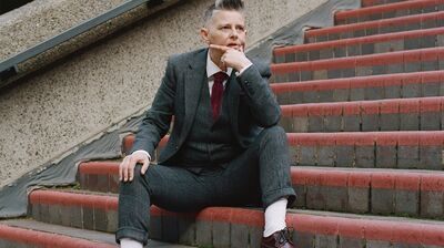 Joelle Taylor sitting on concrete steps with her head resting on her fist.