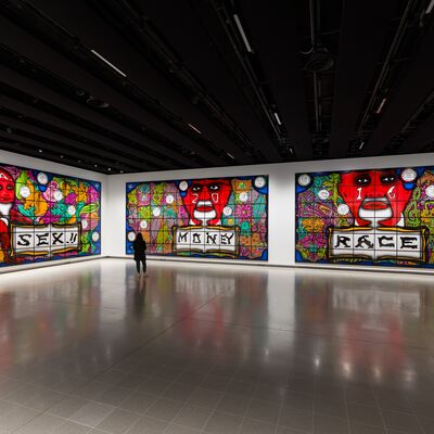 Three large artworks of a red face and other colourful elements with the words 'Sex!!, Money and Race' on each