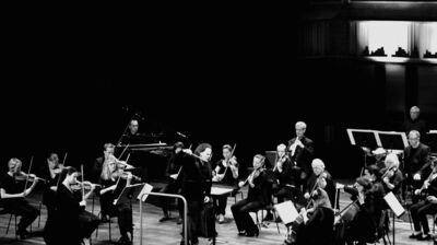 A dark high contrast image of the musicians of London Sinfonietta