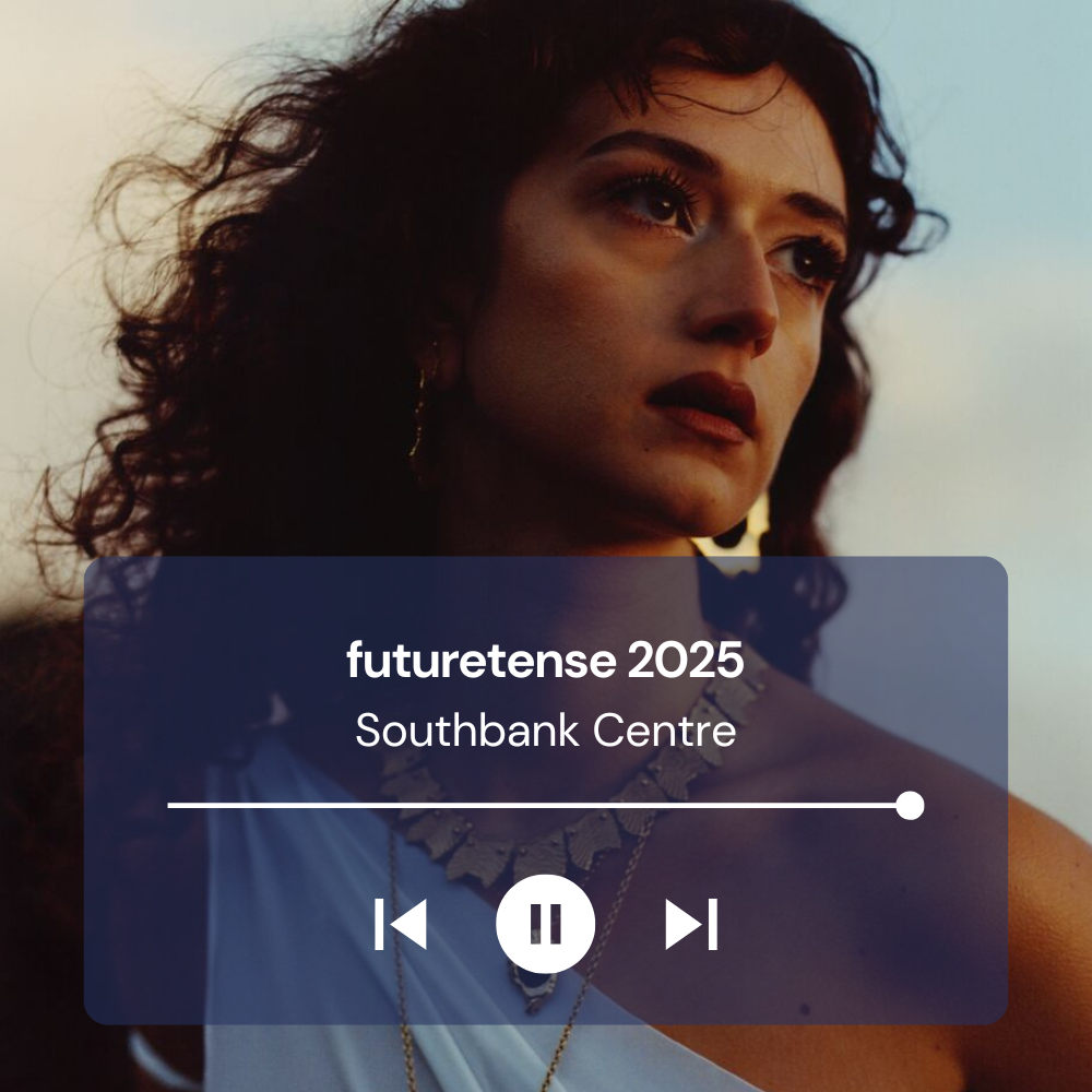 Rosa is looking away from the camera wearing gold jewellery and a blue asymmetric top