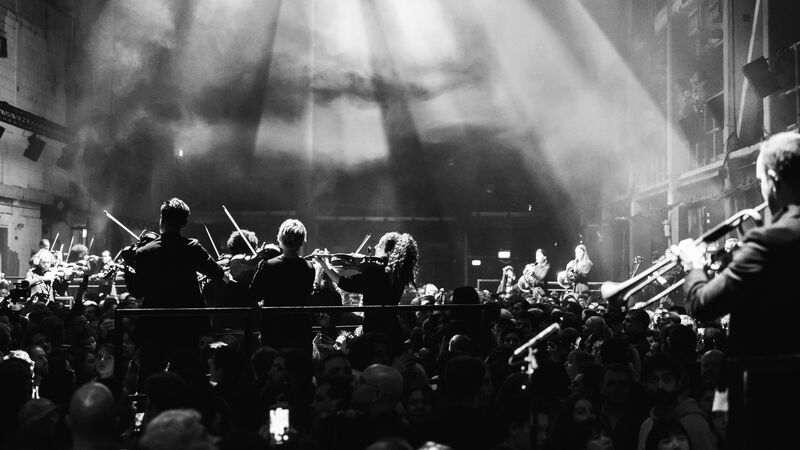 An orchestra performing amongst the audience in an immersive concert