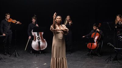 Deaf actor Vilma Jackson singing with musicians of a string ensemble