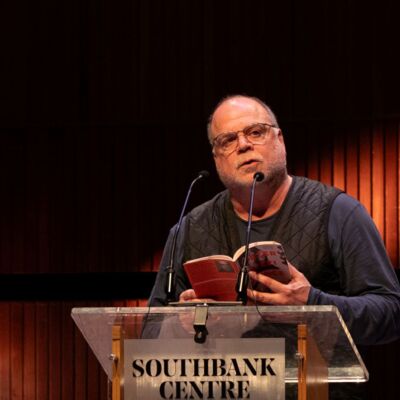 Peter Gizzi standing at a lectern reading from his poetry collection.