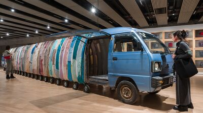 Two people admire a mini van that stretches into the distance