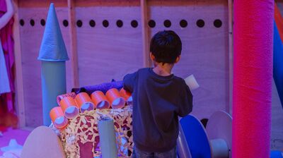 A child playing in a toy castle.