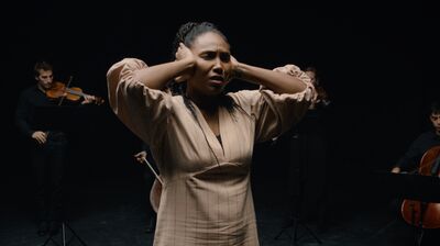 Deaf actor Vilma Jackson singing with musicians of a string ensemble