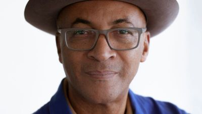 Colin Grant wearing a blue shirt and brown hat.
