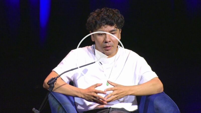 Writer Ocean Vuoung seated on stage at the Southbank Centre's Queen Elizabeth Hall; he wears a white t-shirt