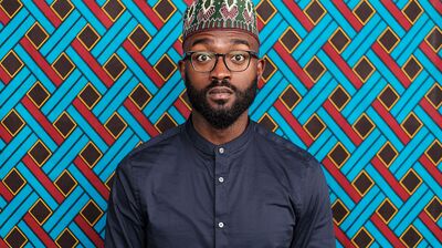 A profile photograph of a man with a beard wearing a colourful kufi hat