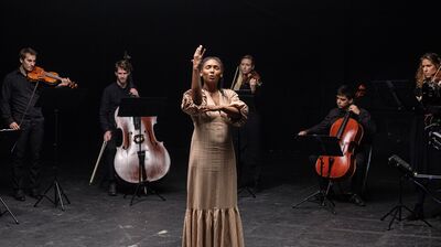 Deaf actor Vilma Jackson singing with musicians of a string ensemble