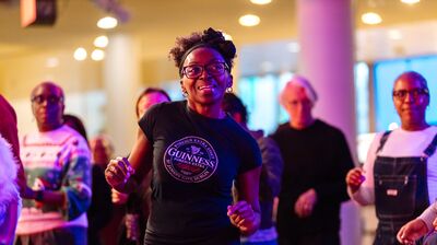 People dancing and smiling with purple lighting