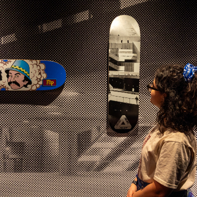 A woman stands in front of two skateboards hanging on a wall