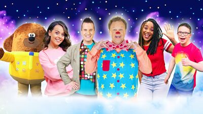 CBeebies presenters, Mr Tumble, and Hey Duggee smile playfully together against a starry night sky and colorful clouds.