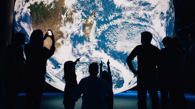 Luke Jerram's Gaia on display in Belfast, with audience members silhouetted in front of it