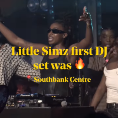 Little Simz wears a black top and sunglasses while she DJs