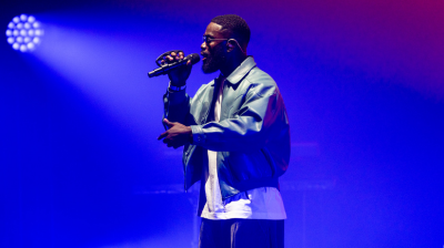 Ghetts on stage bathed in blue light