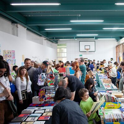 Rows of tables with zines and crowds of people walking between