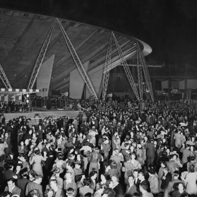 A black and white image of people dancing in front of the Dome of Discovery