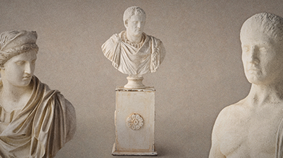 Three ivory coloured statues against an ivory background.