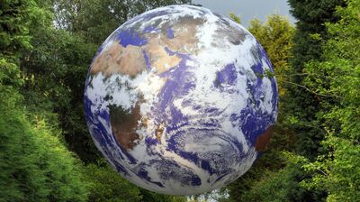 Luke Jerram's Gaia surrounded by trees.