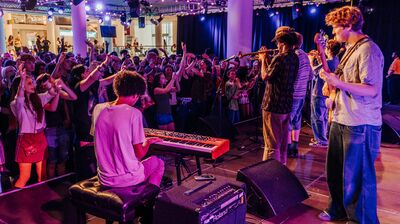 Musicians on stage performing with someone
