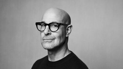Black and white image of Stanley Tucci wearing a plain T Shirt.