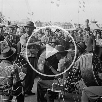 Lieutenant Joseph Nathaniel Griffith conducts the Trinidad All-Steel Percussion Orchestra during their first public performance at the Festival of Britain on 26th July 1951 as an interested crowd watches on.