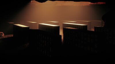Rows of rectangular server racks inside a dark cave, illuminated by a dramatic beam of warm overhead light.