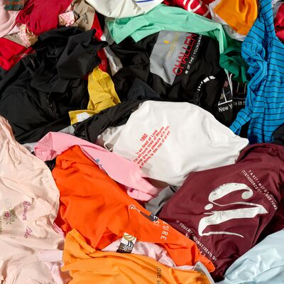 A pile of colourful T-Shirts randomly arranged.