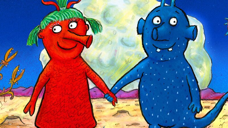 A colorful children's illustration of a red alien and a blue alien holding hands on a desert planet under a huge moon.